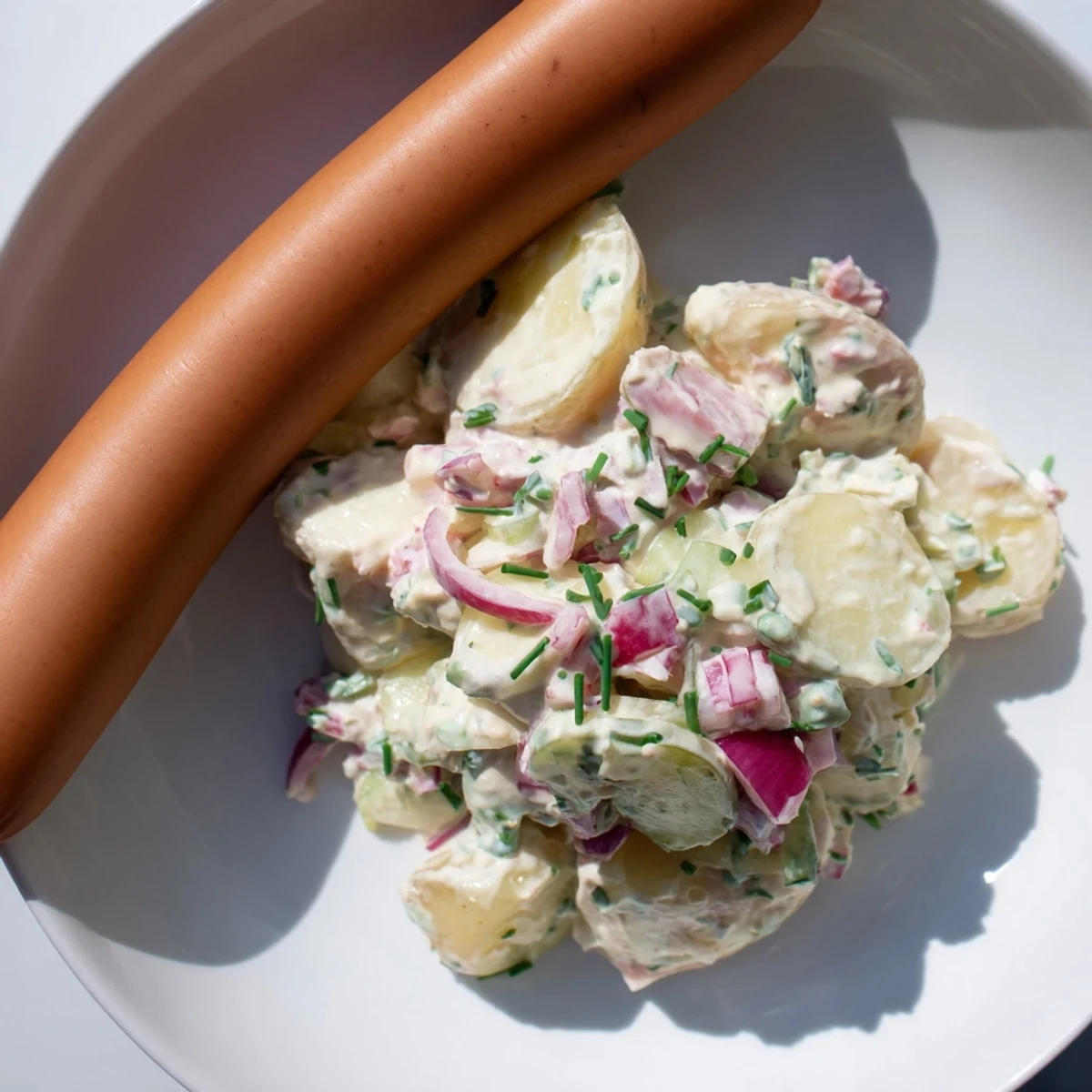 A close-up of delicious German Potato Salad with Sausages, ready for a satisfying family dinner.