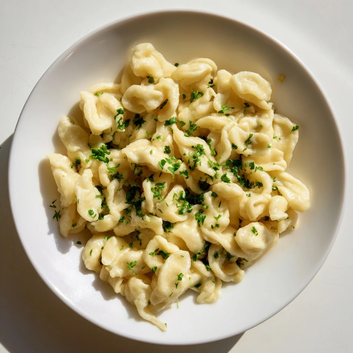 Golden-brown spaetzle, perfectly sautéed with butter and fresh parsley, ready to be enjoyed.