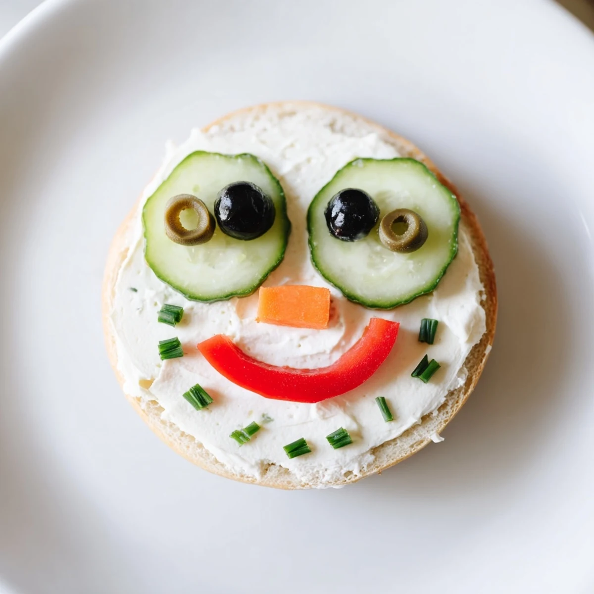 Mini bagel sandwiches decorated as snowmen, a delightful kid-friendly lunch with sliced olive eyes.