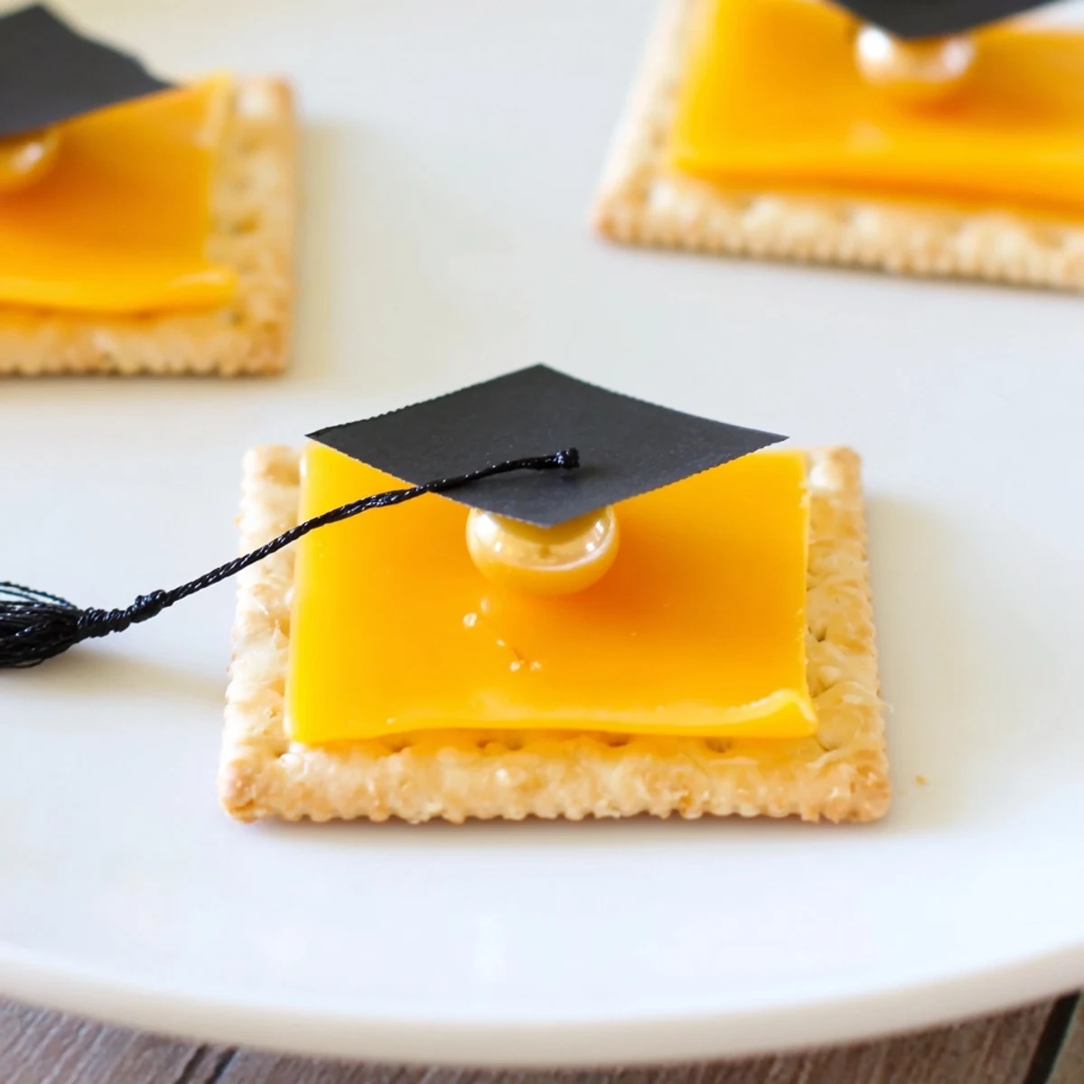 Close-up of a delicious Graduation Cap Snack, with cheese "caps" and a sweet licorice tassel for a celebratory treat.