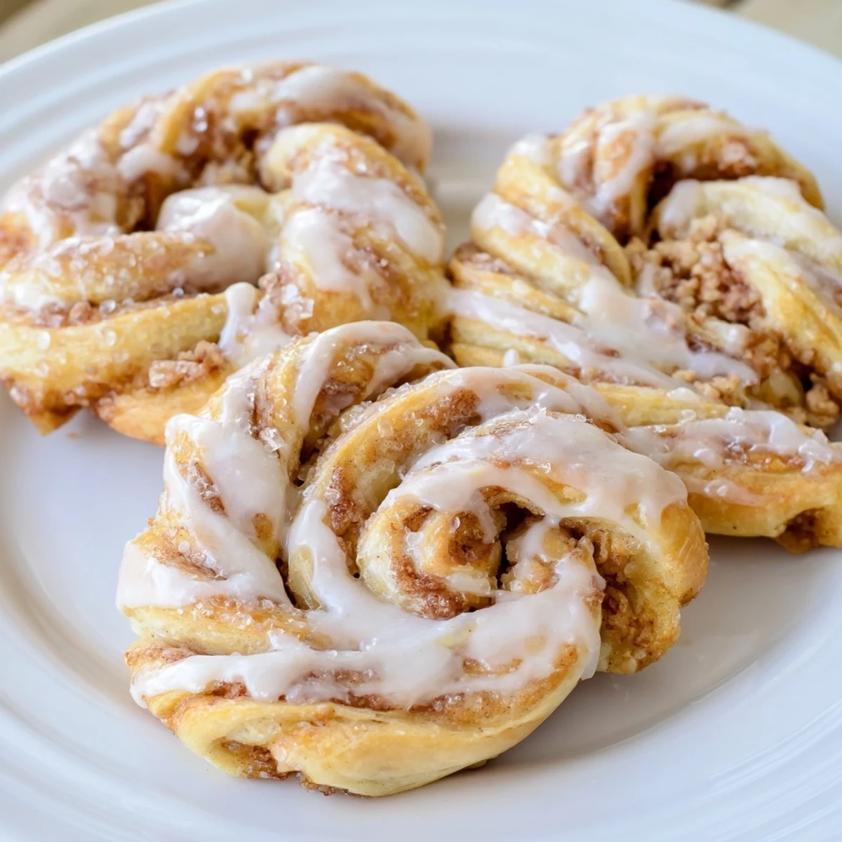 Warm, glazed air-fryer cinnamon roll twists, a quick and easy breakfast idea with a flaky texture.