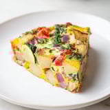 A beautiful, Italian-inspired potato and vegetable frittata, showcasing tender potatoes and colorful bell peppers.