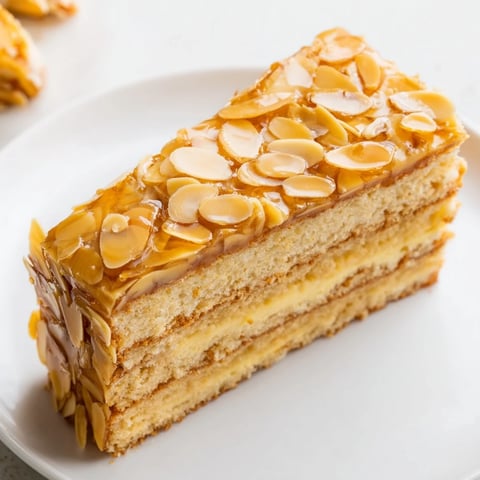 Bee Sting Cake with a golden almond topping and creamy vanilla filling, ready to eat.