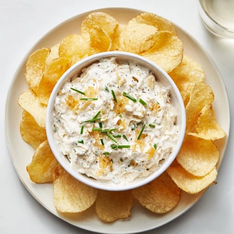 Crisp potato chips surround creamy onion dip, a perfect pairing for your next snack attack.