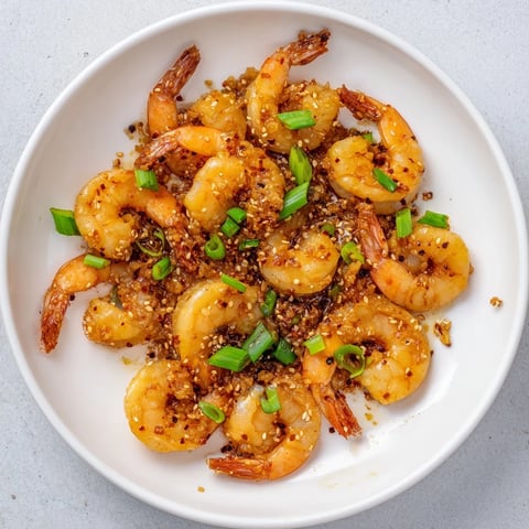 Korean Garlic Butter Shrimp sizzling in a skillet, glistening with a spicy garlic butter sauce.
