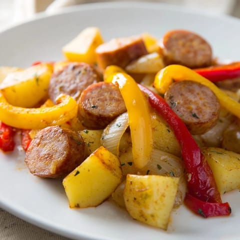 Oven-baked 1-Pot Kielbasa and Potato Bake with browned sausage and colorful peppers, ready to serve.