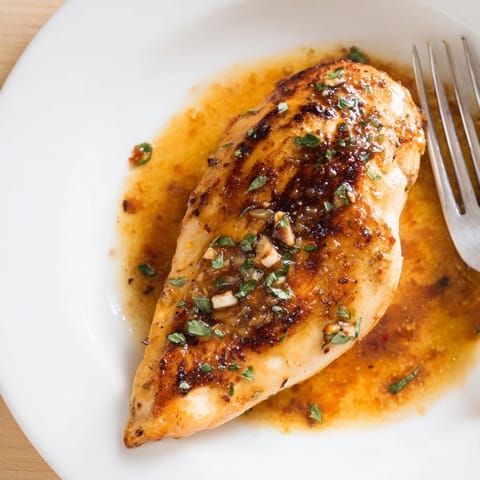 Goldbraune Hähnchenbrustfilets in einer cremigen Honig-Senf-Sauce garniert mit frischer Petersilie.