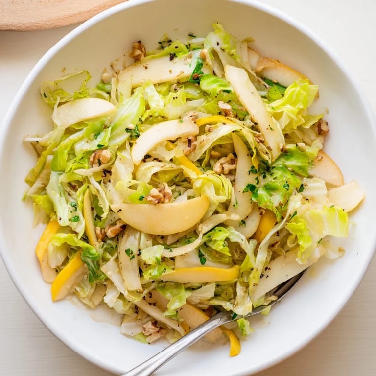 Vibrant cabbage and apple stir fry, garnished with toasted nuts for crunch.