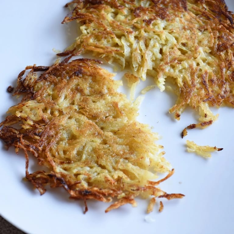 A close-up shot of German potato pancakes, showing their beautifully browned, textured surface.