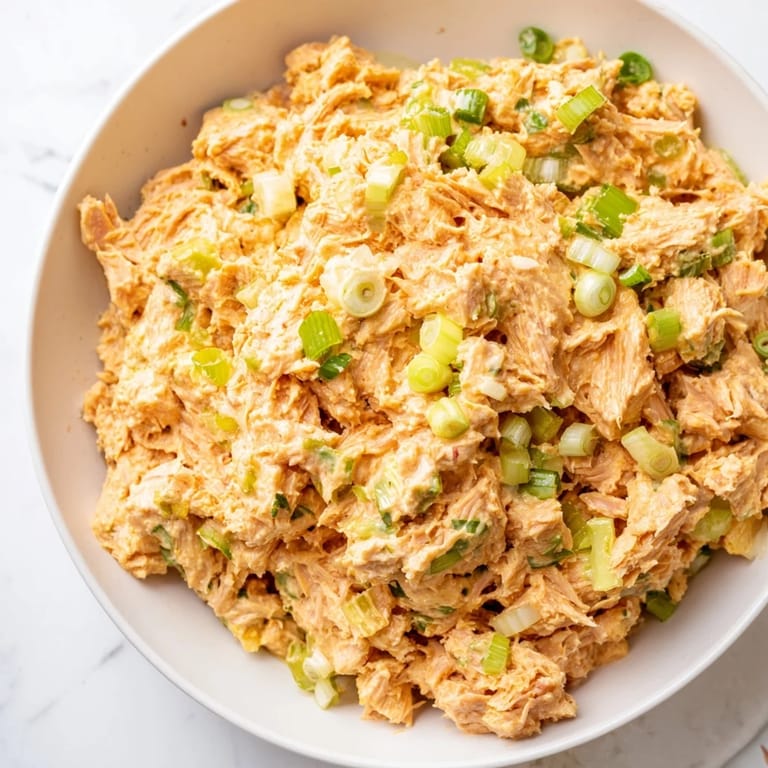 Ready-to-serve spicy zesty tuna salad piled onto toasted bread, topped with fresh scallions for a light, protein-packed lunch.